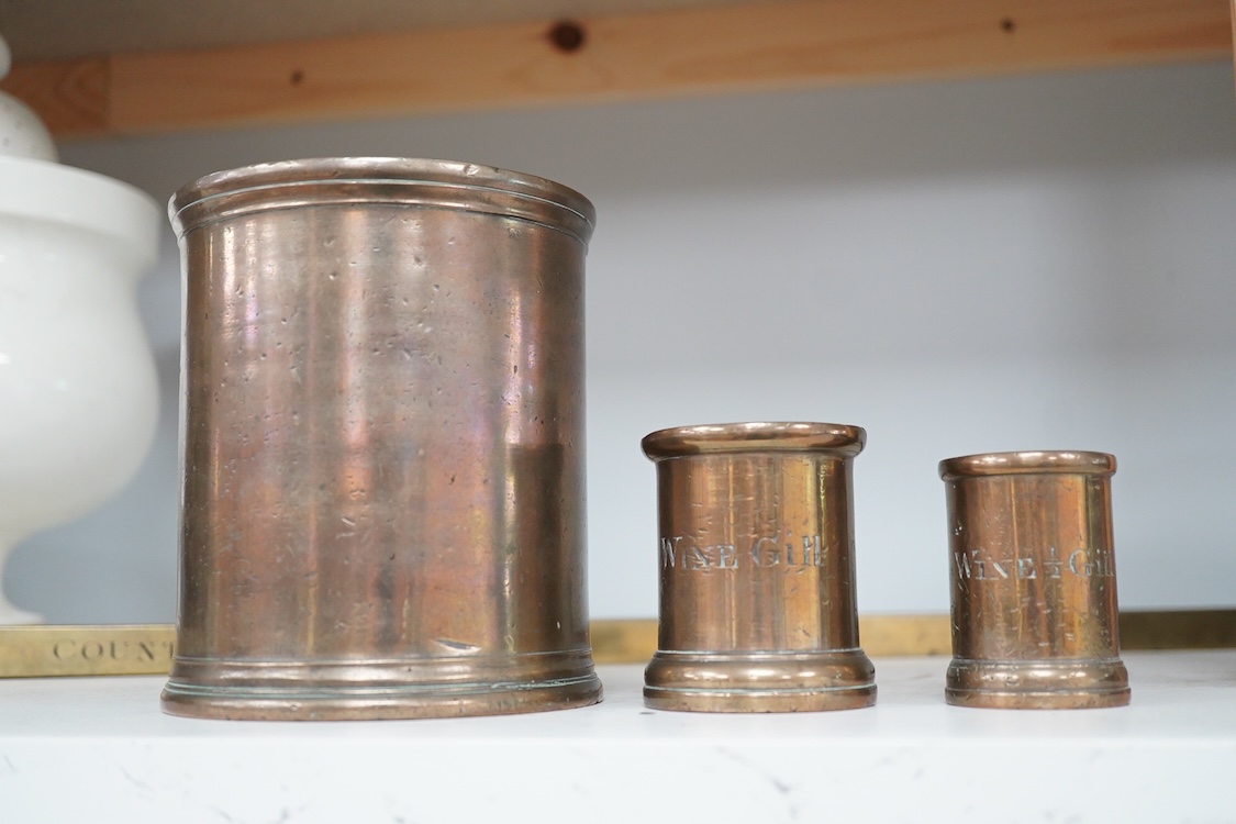 Three 19th century bell metal wine gill measures, two smaller examples engraved; ‘wine hill’, tallest 13.5cm